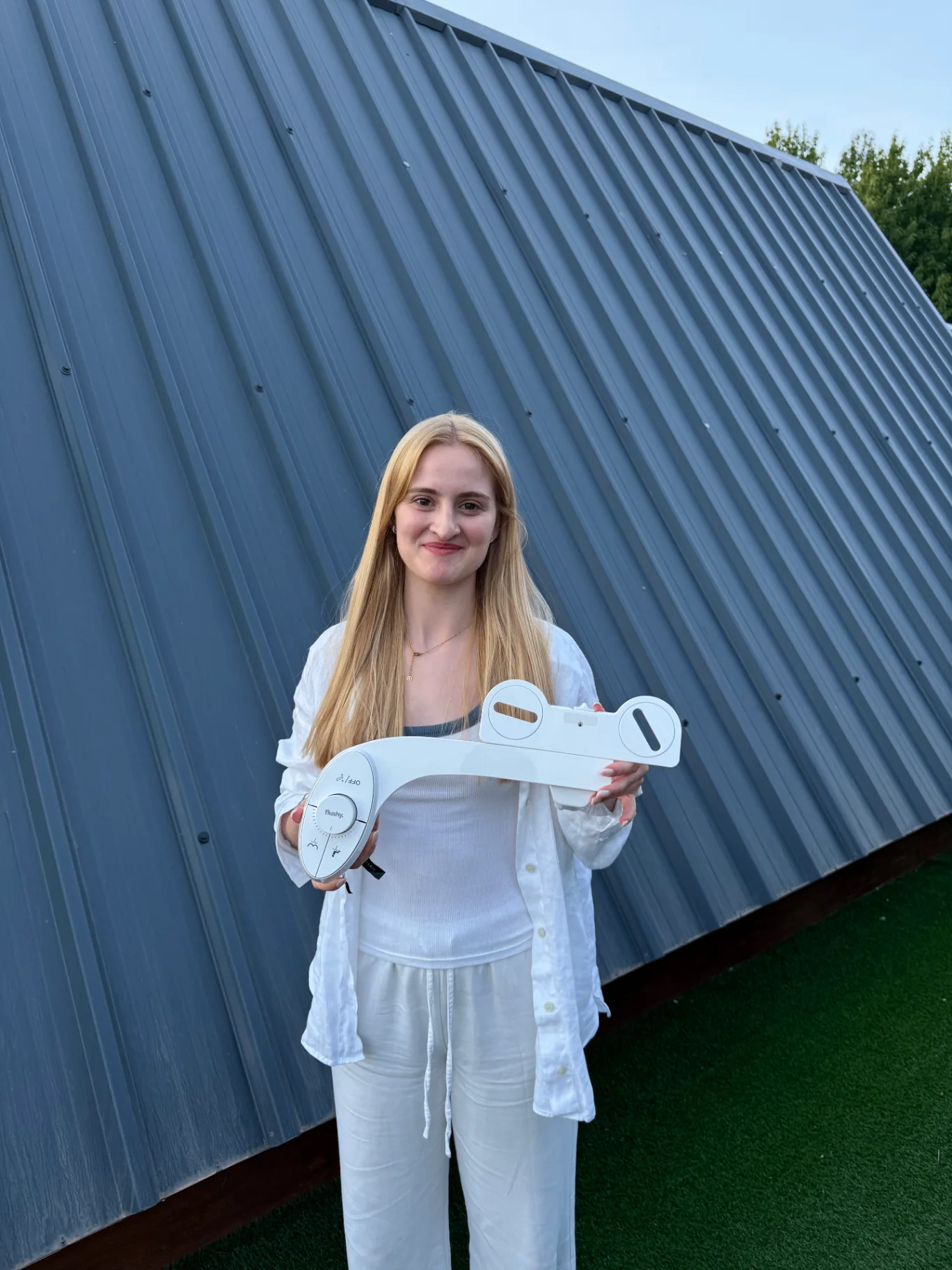 Woman holding a Flushy bidet outdoors